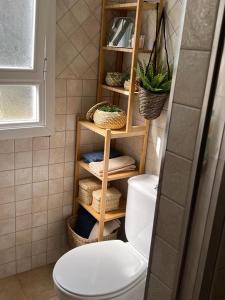 a bathroom with a toilet and a shelf with baskets at Casa en Laredo in Laredo