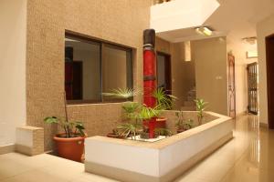 a corridor with plants in a building at Hotel Residence Flamani in Lomé