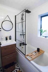 a bathroom with a tub and a sink and a shower at Oasis in English Village in Crowthorne