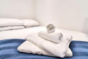 a pile of towels sitting on top of a bed at Cozy Guest Lodge with a large secluded garden in Stifford