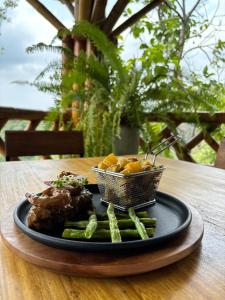 een bord met vlees en groenten op tafel bij La Veranda Hotel & Restaurant in Minca