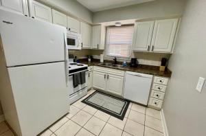 a kitchen with white cabinets and a white refrigerator at Cathedral 1-Walking Distance to UNMC in Omaha