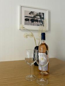 una botella de vino y dos copas de vino en una mesa en Gemütliche Wohnung Landlust in See-Nähe, en Tauche