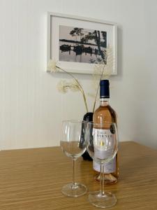 a bottle of wine and two wine glasses on a table at Gemütliche Wohnung Landlust in See-Nähe in Tauche +7 photos