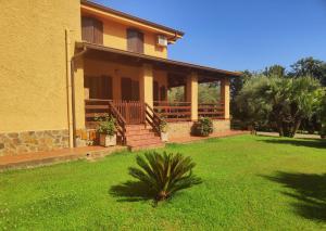 een huis met een groen gazon ervoor bij Nuraghe Bianco in Santa Maria la Palma