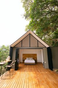 a house with a bed on a wooden deck at Glamping MontdeLuxe in Yopal