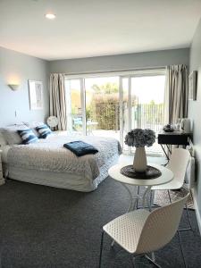 a bedroom with a bed and a table and chairs at Mount Pleasant Views in Christchurch