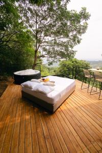 a bed on a wooden deck with a bath tub at Glamping MontdeLuxe in Yopal