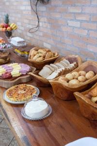 a table topped with lots of different types of bread at Hotel Vila das Palmeiras in Altinópolis