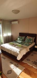 Un dormitorio con una cama grande con almohadas. en Apartman Centar, en Bijeljina