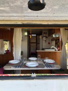 a table with plates and glasses on top of it at Trailer em Sítio in Timbó +20 photos