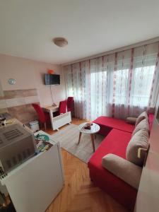 a living room with a red couch and a table at Apartman Centar in Bijeljina