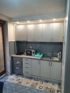a kitchen with white cabinets and a microwave at Apartman Lux K in Bijeljina