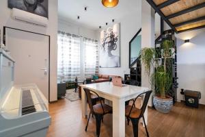 een eetkamer met een witte tafel en stoelen bij Superbo Loft radical chic in Quartu SantʼElena