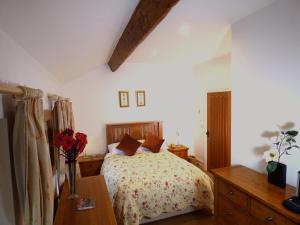 a bedroom with a bed with flowers on it at Renovated Farmhouse in Picturesque Eskdale Valley in Holmrook