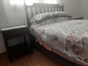 ein Schlafzimmer mit einem Bett und einem Nachttisch mit einem Bett von 6 x 6 cm in der Unterkunft Posada Santa Elena (1 cama) in Santa María Atlihuetzián