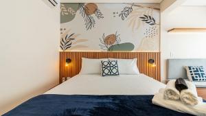 a bedroom with a bed and a wall with plants at Studios modernos e completos ao lado da estação Vila Mariana in Sao Paulo