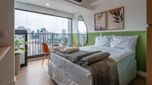 a bedroom with a bed and a balcony at Studios modernos e completos ao lado da estação Vila Mariana in Sao Paulo