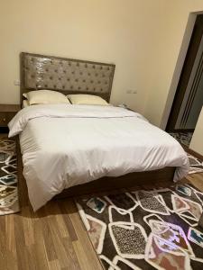 a bedroom with a large bed with a headboard and a rug at الشيخ زايد in Sheikh Zayed