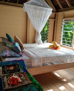 a bedroom with a bed with a mosquito net at Hideaway Paradise Beach Bungalows in Hog Harbour