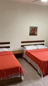 um quarto com duas camas e uma foto na parede em Jasmim Manga pousada e Cafe em Ubatuba
