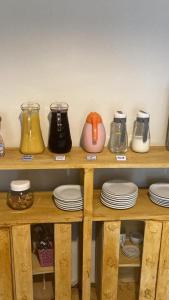 a shelf filled with different types of jars and plates at Jasmim Manga pousada e Cafe in Ubatuba