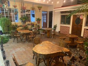 a restaurant with wooden tables and chairs and plants at Hostal San José in Somoto