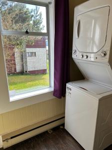 una lavatrice e asciugatrice in una stanza con finestra di Alert Bay Sweet Home ad Alert Bay