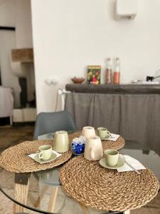 a glass table with cups and saucers on it at Casa Lina in Ostuni