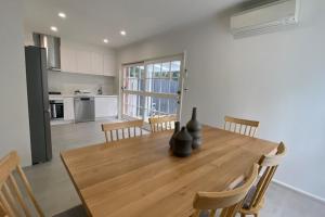 a kitchen and dining room with a wooden table and chairs at Elegant 2-bedroom House in Prahran w Parking! in Melbourne