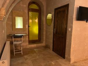 a hallway with a door and a table and a stool at Cappadocıa Tuğhan Stone House in Nevşehir