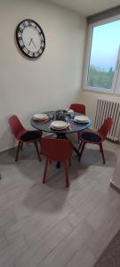 comedor con mesa, sillas y reloj en Apartman Sunset, en Osijek