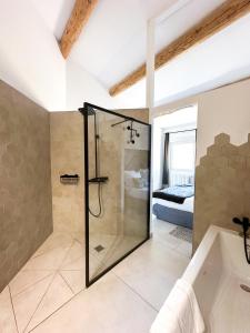 La salle de bains est pourvue d'une douche et d'une baignoire. dans l'établissement Hôtel d'Angleterre, Salon-de-Provence, à Salon-de-Provence