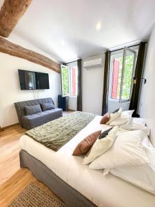 - une chambre avec un grand lit et un canapé dans l'établissement Hôtel d'Angleterre, Salon-de-Provence, à Salon-de-Provence