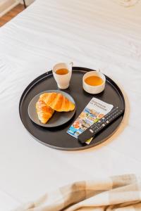 a tray with a plate of food and two cups of tea at Hôtel d'Angleterre, Salon-de-Provence in Salon-de-Provence