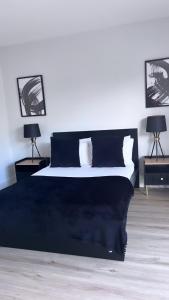 een slaapkamer met een zwart-wit bed met 2 lampen bij 3 Bedroom House Near City Centre Glasgow Sleeps 7 in Glasgow