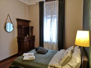 sypialnia z łóżkiem z lampką i oknem w obiekcie Charlotte Apartment w Tarnowie