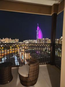 uma varanda com vista para a cidade à noite em Luxury Room Burj al Arab FRONT em Dubai
