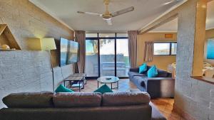 ein Wohnzimmer mit einem Sofa und einem Tisch in der Unterkunft Riverview Holiday Apartment 13 - Kalbarri, WA in Kalbarri