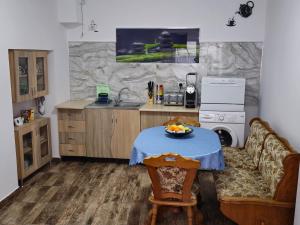 a kitchen with a couch and a table with a bowl of fruit on it at ELDI House in Făgăraş