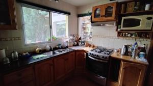 a kitchen with a stove and a sink and a window at Casa de Silvina in El Bolsón