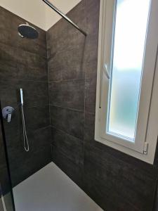 a shower with a glass door and a window in a bathroom at Appartamento al mare - Punta Marina in Punta Marina