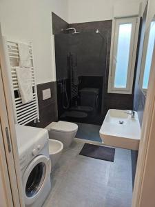a bathroom with a toilet sink and a washing machine at Appartamento al mare - Punta Marina in Punta Marina +6 photos