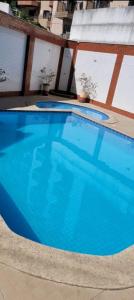 a large blue swimming pool in a building at Apartamento Duplex (Cobertura) Praia do Forte in Cabo Frio