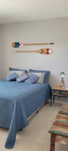 a bedroom with a bed with a surfboard on the wall at Apartamento Duplex (Cobertura) Praia do Forte in Cabo Frio