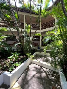 a courtyard of a building with trees and plants at Pousada Casarão 2030 in Natal