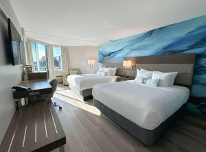um quarto de hotel com duas camas e uma pintura azul na parede em Coast Bastion Hotel em Nanaimo