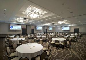 a room filled with tables and chairs with white linens at Coast Bastion Hotel in Nanaimo