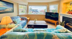 a living room with blue couches and a tv at Marine Melody in Nanaimo