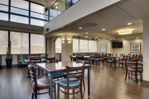 uma sala de jantar com mesas, cadeiras e janelas em Drury Inn & Suites Cape Girardeau em Cape Girardeau